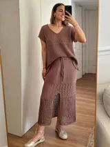 Remera color marrón de hilo de algodón con punto calado, escote en V, manga corta, silueta oversize y tajos laterales.