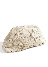 Cartera clutch color beige de crochet con diseño floral y aplique de caracoles en el centro de una de las flores.