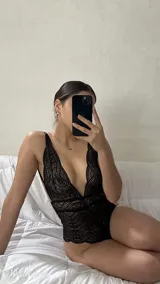 Body de encaje negro con escote pronunciado en V, breteles regulables y diseño entallado.