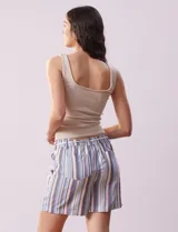 Short color crema con finas rayas verticales grises, pretina elastizada con cordón de ajuste, bolsillos delanteros y traseros.