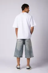 Bermuda de jean con corte baggy y lavado vintage en tono marrón oscuro. Presenta un diseño amplio y cómodo con bordes deshilachados en el ruedo, evocando un estilo nostálgico de los años 2000.