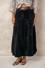 Pollera larga de pana color chocolate, con diseño de tablas frontales y bordados florales en toda la superficie. Cuenta con cintura con pasacintos.