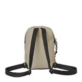 Bandolera tipo mochila pequeña New Balance, color beige con detalles en negro y blanco. Presenta el logo 'N' grande en el frente y el nombre de la marca en el bolsillo delantero. Cuenta con dos compartimentos con cierre y correa ajustable.