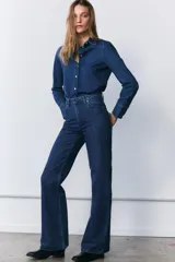 Jeans de tiro medio con corte recto, confeccionados en tejido de algodón. Presentan cintura con trabillas, cierre frontal con cremallera y botón, y diseño de cinco bolsillos.