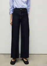 Jeans culotte de tiro alto en color azul oscuro, con diseño de pernera ancha, bajo deshilachado, cierre de cremallera y botón, y bolsillos traseros.