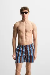 Short de baño confeccionado en tejido técnico con diseño de rayas verticales en tonos azul, marrón y beige. Cuenta con cintura elástica ajustable con cordón, bolsillos laterales y forro interior.