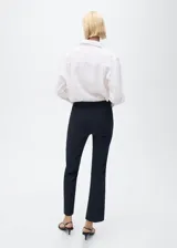 Pantalón de corte recto y diseño crop, color negro, con trabillas en la cintura, dos bolsillos laterales y cierre frontal de gancho y cremallera.