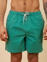 Short de baño tipo volley color amarillo claro, con cintura elástica y cordón ajustable. Presenta un diseño liso con un pequeño logo bordado en la parte inferior de la pierna izquierda.