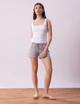 Conjunto de pijama de dos piezas marca René Rofé, compuesto por un top blanco de breteles finos y un short gris con rayas horizontales blancas, cintura elastizada y cordón de ajuste.