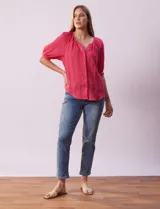 Blusa color fucsia con estampado de rayas verticales y flores, cuello redondo con escote en V y mangas cortas abullonadas.