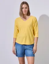 Buzo amarillo de algodón marca Ninety, con escote en V y mangas 3/4. Tejido fino con pespuntes verticales en el centro del frente y la espalda.