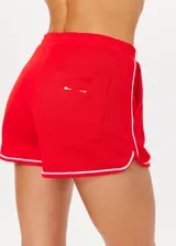 Short deportivo rojo con ribetes blancos, de tiro medio, con bolsillos frontales y bolsillo trasero.