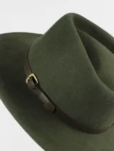Sombrero de ala ancha confeccionado en lana impermeable, color verde oliva, con detalle de cinta de cuero marrón y hebilla metálica lateral.