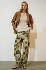 Pantalón jeans ZW Collection de tiro medio y corte balloon, confeccionado en algodón con diseño estampado de flores en tonos oscuros sobre base beige. Cuenta con cinco bolsillos, trabillas para cinto y cierre frontal con cremallera y botón metálico.
