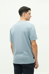 Remera de manga corta color ladrillo con bolsillo en el pecho y estampado pequeño de una palmera.