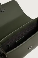 Bandolera de hombre con acabado engomado en color negro, con solapa frontal texturizada y cierre de botón a presión. Cuenta con correa de hombro ajustable e incluye un pequeño monedero desmontable con cierre.