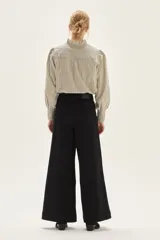 Jean de tiro alto, pierna ancha y color negro. Presenta costuras marcadas en el frente que recorren verticalmente la pierna.