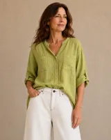 Camisa verde pistacho de lino, con cuello mao, cierre frontal con botones y dos bolsillos plaqué en el pecho. Las mangas son largas con presilla para sujetar arremangadas.