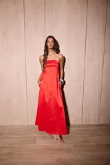 Vestido largo azul con escote strapless, corte suelto y fluido, confeccionado en tafeta con efecto tornasolado, y bolsillos ocultos en los laterales.