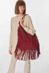 Bolso tipo hobo de cuero color bordó con flecos largos en la parte inferior.