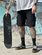 Bermuda cargo color verde militar con bolsillos laterales con solapa, corte recto y largo hasta la rodilla.