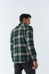 Sobrecamisa de algodón a cuadros color ladrillo, con interior de corderito, cierre con botones, bolsillos tipo cartera y logo en goma. El modelo usa talle M.