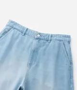 Pantalón de jean corte baggy, de tiro alto y pierna ancha, con diseño de cinco bolsillos, trabillas para cinturón y cierre frontal con botón y cremallera.