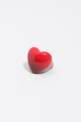 Anillo de resina color rojo con diseño abultado en forma de corazón y acabado brillante.