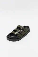 Sandalia negra tipo slide con plataforma gruesa y tres tiras ajustables con hebillas metálicas plateadas. La capellada es de material con textura de gamuza o nobuck.