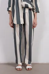 Pantalón recto de tiro medio con cintura elástica y corte holgado. Diseño a rayas verticales en tonos verde y blanco.