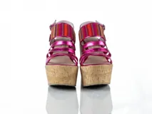 Sandalias de plataforma corrida revestida en corcho, con tiras delanteras de cuero fucsia brillante y tira ancha superior con detalles textiles multicolor estilo aguayo. Presenta cierre con hebilla en el talón.