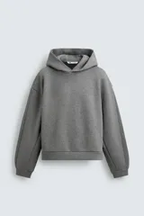Sudadera tipo hoodie de corte boxy fit, confeccionada en tejido doble y compacto de mezcla de algodón. Presenta cuello con capucha, manga larga y acabados en el mismo tejido.