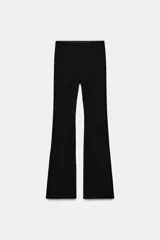 Leggings de tiro alto con corte acampanado, confeccionados en tejido negro con detalle de abalorios brillantes distribuidos por toda la prenda.