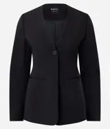 Blazer sastre Blue Steel de color negro, confeccionado en poliéster con elastano y forro de poliéster. Presenta un diseño estructurado con escote en V pronunciado, cierre frontal de un botón y bolsillos con solapa en los laterales. Las mangas largas tienen volumen tipo cocoon.