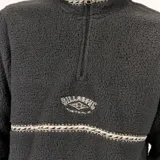 Buzo de polar tipo sherpa color negro, con cuello alto y cierre frontal parcial. Presenta detalles de cinta tejida con patrón geométrico en el cuello, el pecho y los bolsillos frontales, además del logo de la marca bordado en el centro del pecho.