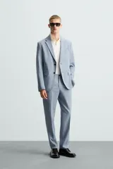 Pantalón de vestir corte slim fit, confeccionado en tejido con lana, con bolsillos frontales y traseros de doble vivo con botón.