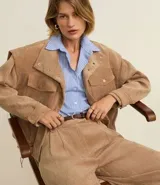 Campera de terciopelo cotelê color beige, con cuello solapa, abotonada al frente y bolsillos con solapa en el pecho. Tiene sisas desplazadas y tiradores ajustables en el ruedo.