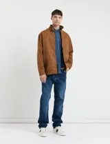 Camisa de jean de manga larga con cuello clásico, cierre frontal con botones y bolsillo tipo parche en el pecho.