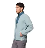 Buzo polar con cierre frontal completo de la marca Columbia. Presenta un diseño en color azul claro con paneles superpuestos en un tono azul más oscuro en la zona del pecho y cuello. Incluye bolsillos laterales con cierre, cuello alto y detalles en color amarillo neón en los tiradores de los cierres.