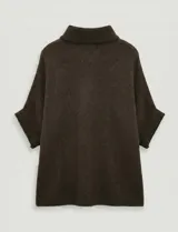 Capa tejida color fucsia, con cuello alto abotonado y mangas cortas estilo japonesa. Tejido de punto grueso.