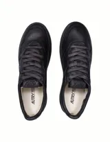 Championes de cuero negro con diseño de corte bajo, cordones al tono y suela de goma negra. Presenta el logo de la marca Autry con la bandera de Estados Unidos en el lateral.