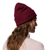 Gorro tipo beanie de punto color bordó con vuelta en el borde y etiqueta pequeña con el logo de la marca Columbia en gris.