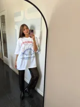 Remera oversize blanca de manga corta con estampado frontal de un pez azul y texto en rojo.