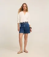 Short de jeans azul oscuro, tiro alto, con dobladillo en el ruedo y trabillas para cinturón.