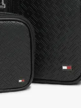 Cartera tipo sling Tommy Hilfiger de color negro, con diseño texturizado, bolsillo frontal con cierre y correa ajustable.