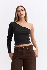 Remera de manga larga con diseño de un solo hombro, confeccionada en algodón con textura acanalada y ajuste al cuerpo.