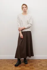 Falda larga de jean color azul oscuro con corte evasé y costuras con pespuntes a contratono. Presenta una cintura elástica para mayor comodidad.