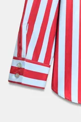 Camisa de manga larga con cuello subido y detalle de lazada frontal. Presenta un diseño de rayas verticales en tonos verde y celeste, con cierre frontal de botones y puños clásicos.