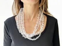 Collar de varias vueltas con cuentas ovaladas transparentes unidas por hilo de nylon blanco.