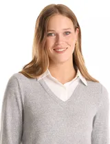 Buzo combinado de hilado fino color gris, con cuello en V y mangas largas. Presenta una pieza inferior y cuello tipo solapa en tela blanca que simula una camisa debajo.